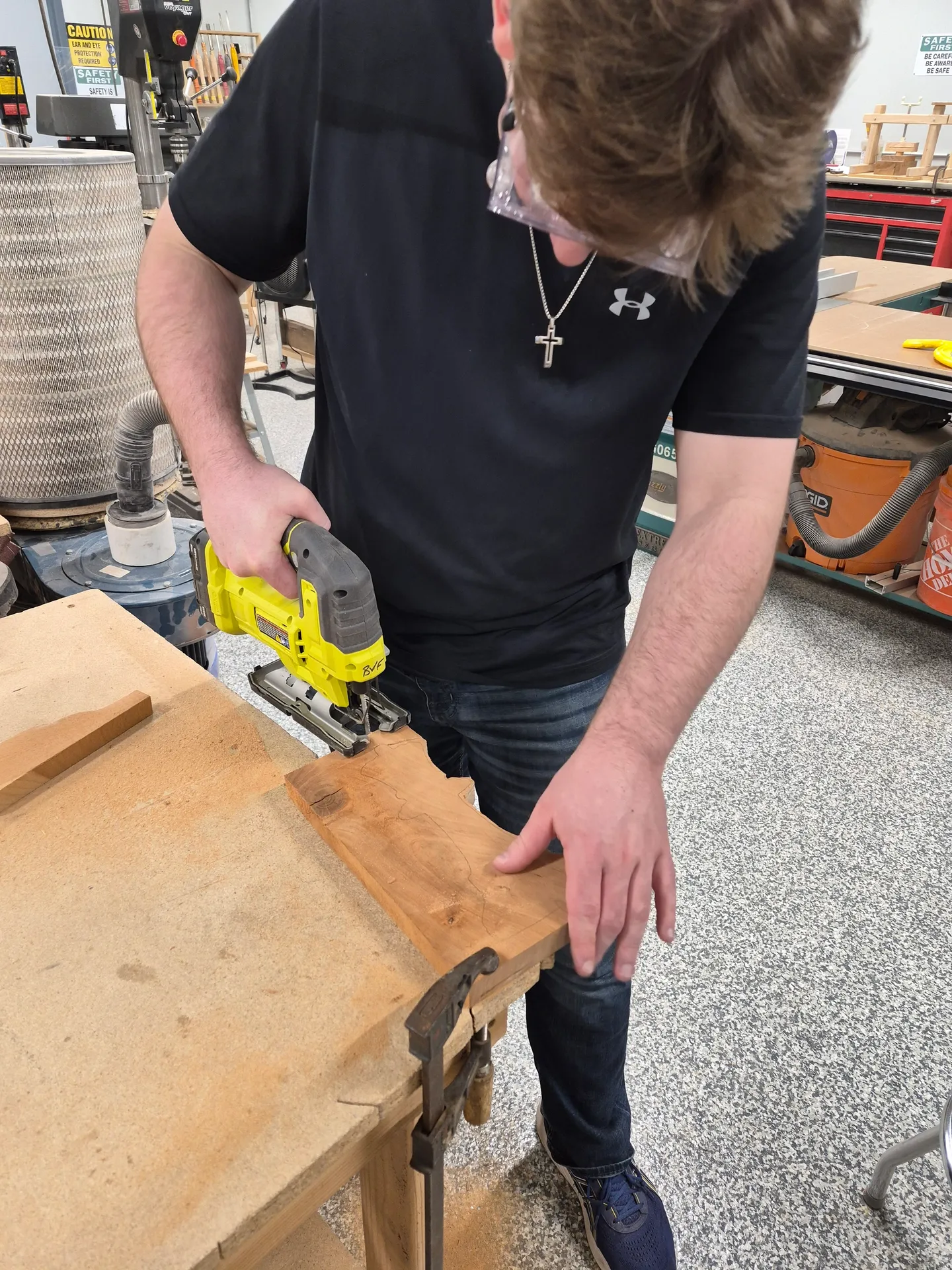 A veteran cutting a piece of wood with a jigsaw in a woodworking shop