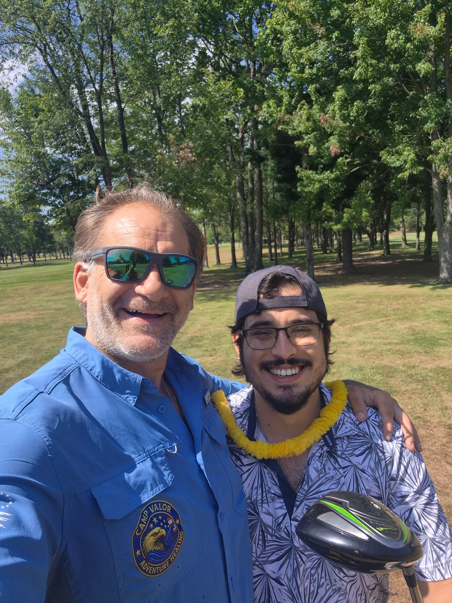 Mike Brandow taking a selfie on the golf course with another veteran