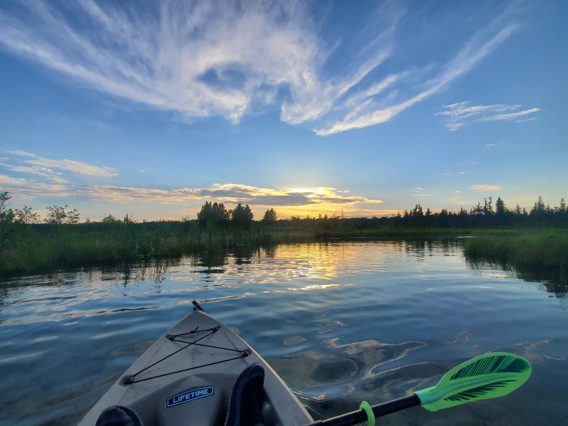 A kayak on calm water at sunset
