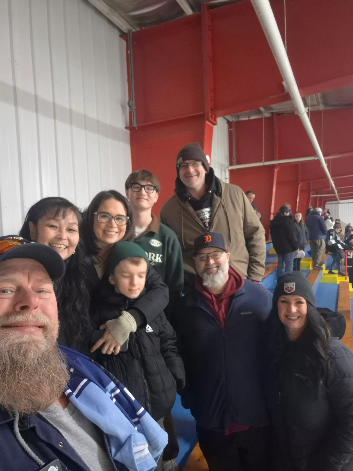 A group selfie of families at a hockey game